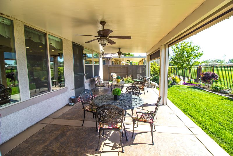 modern verandha with chairs and a table and a roof fan